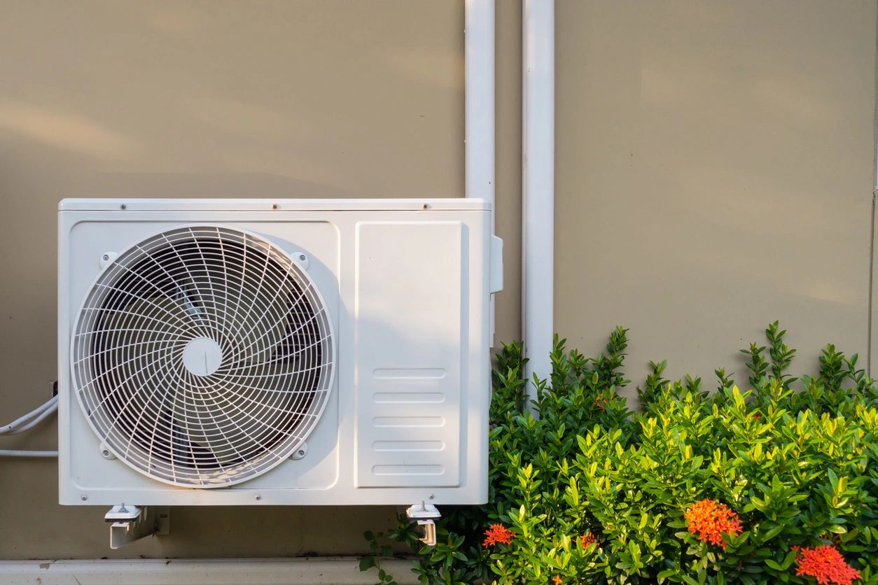 A white air conditioner sitting on top of a building.