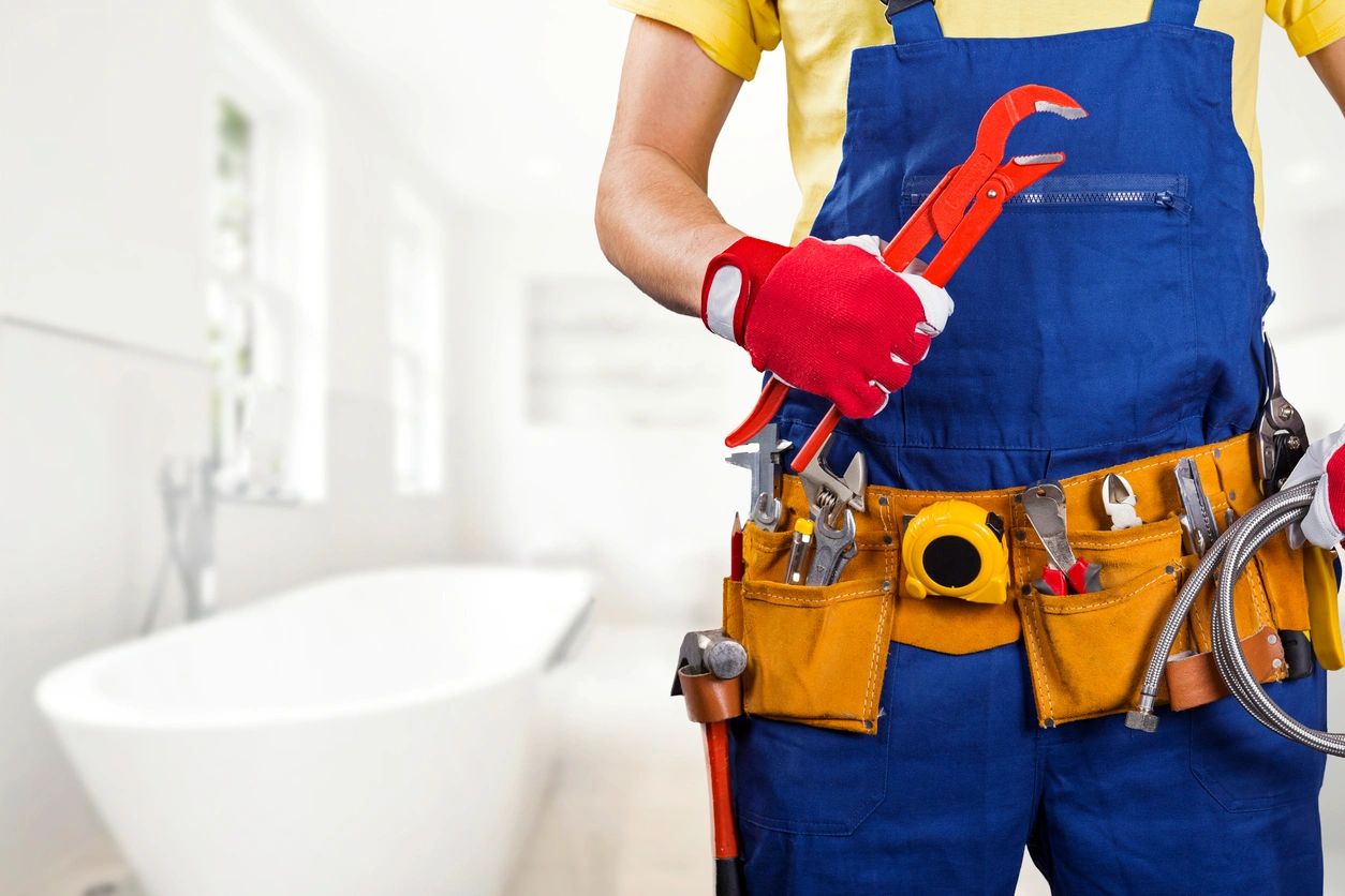 A person holding tools in their hands while wearing an apron.